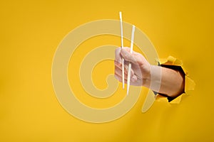 Hand holding wooden chopstick