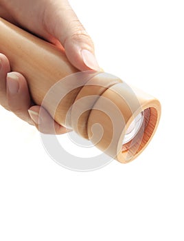 Hand holding wooden pepper grinder