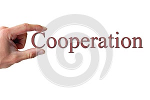 Hand holding the word cooperation