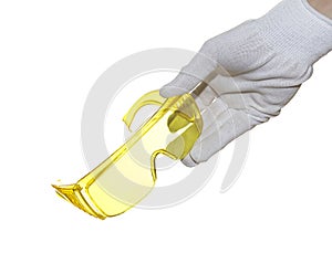 Hand holding yellow safety glasses isolated on white