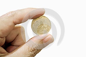 Hand holding 500 Yen Japanese coin