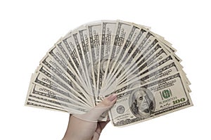 the hand holds 100 dollar bills. A womans hand holds a fan of dollars on an isolated white background. Finance