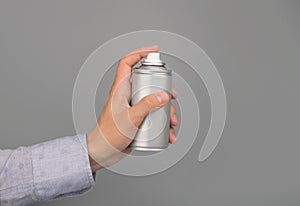 Hand holds aerosol spray can
