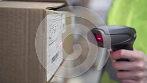 Hand holds a barcode scanner in the warehouse