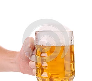 Hand holds big mug with gold beer.