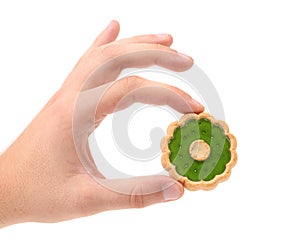 Hand holds biscuit with kiwi jam.