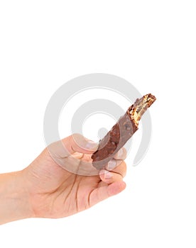 Hand holds bitten chocolate bar.