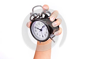 Hand holds a black shiny alarm clock on white background