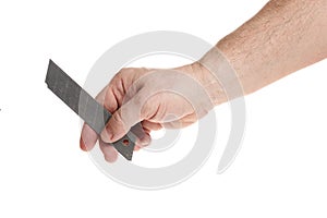 Hand holds a blade for a construction knife on a white background