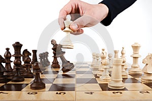 Hand holds a chess king piece and defeats another king