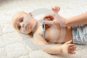 The hand holds a digital medical thermometer with a high temperature on a white isolated background