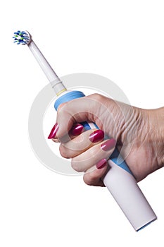 Hand holds electric toothbrush against white
