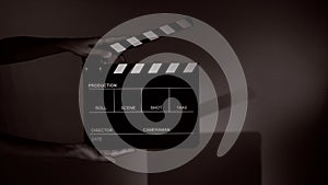Hand holds empty film making clapperboard on color background in studio
