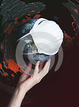 A hand holds the globe with a medical mask during an epidemic of Covid 19 or coronavirus worldwide. Concept