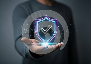 Hand holding glowing neon shield with checkmark and particles technology security