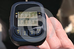 Hand holds a GPS logger with the coordinates of the Equator Zero