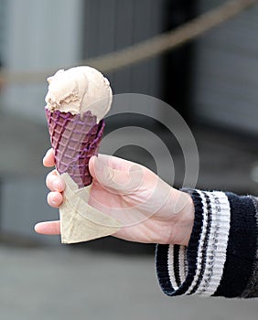 A Hand Holds an Ice Cream Cone, Symbolizing Indulgence