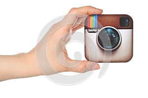 Hand holds Instagram logo printed on paper on white background
