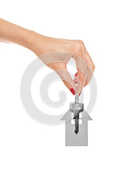 Hand holds key with a keychain the shape of house.