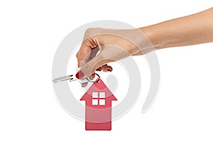 Hand holds key with a keychain the shape of house.