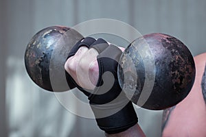 Hand holds an old dumbbell