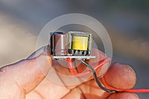 hand holds one small microcircuit with electrical parts