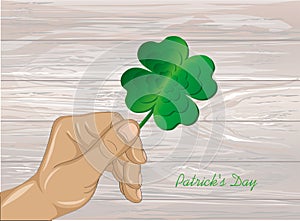 Hand holds ornate clover four-leaf. Celebration concept St. Patr photo