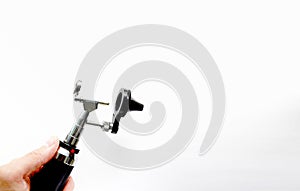 Hand holds Otoscope for ENT doctor exam ear head cone piece view on white background