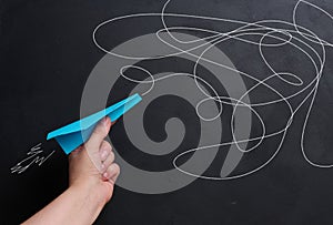 A hand holds a paper airplane with a drawn flight trajectory on the board, representing the concept of support and mentorship