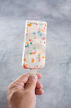 hand holds rainbow cereal paleta