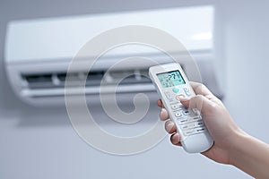 Hand holds remote control, ready to adjust air conditioner settings