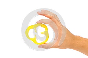 Hand holds slice of yellow pepper.