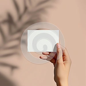 The hand holds a small white sticker. Mock-up for labels, advertising, marketing