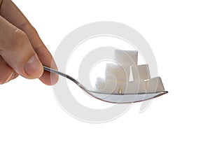 Hand holds spoon with sugar cubes. Isolated on white background