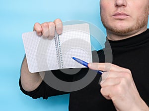 A hand holds a sticker notepad with a pen, an empty space for a free letter to inscribe your text. Message on sticker copy space.