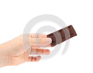 Hand holds tasty morsel of dark chocolate.