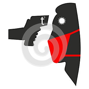 Hand holds thermometer near human face in mask. Temperature check with a laser thermometer during a coronavirus and covid-19,