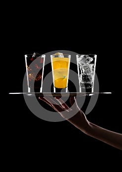 Hand holds tray with glass of cola orange water