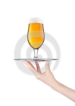 Hand holds tray with lager beer glass with bubbles