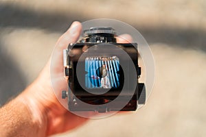 Hand holds a twin-lens reflex camera with a girl& x27;s picture displayed on its screen