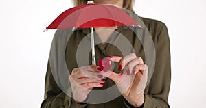 Hand holds umbrella and red heart