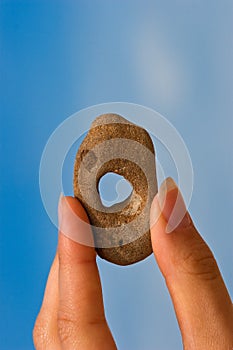 Hand with holey stone photo