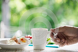 Hand hooding hot coffee cup with boiled eggs photo