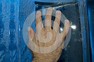 Hand on ice blocks wall