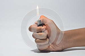 Cropped Hand Igniting Cigarette Lighter Against White Isolated Background