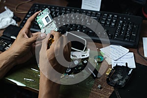 Hand of an Indonesian man repairing a handycam