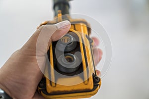 Hand of an industrial mechanic pressing the remote. Man lifting weight power trolley with crane. The remote switch of the crane on