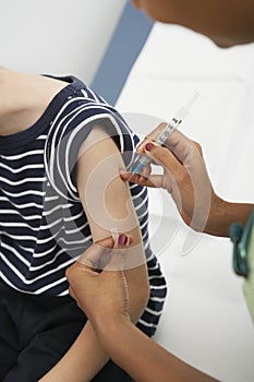 Hand Injecting Vaccine On Boy's Arm photo