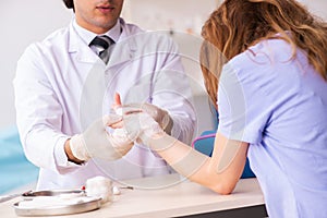 The hand injured woman visiting doctor traumatologist