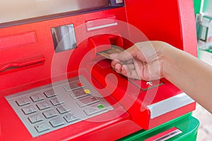 Hand insert credit card to ATM bank cash machine for withdraw mo